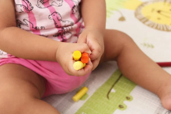 Elinde tebeşir ve kalemle oynayan çocuk