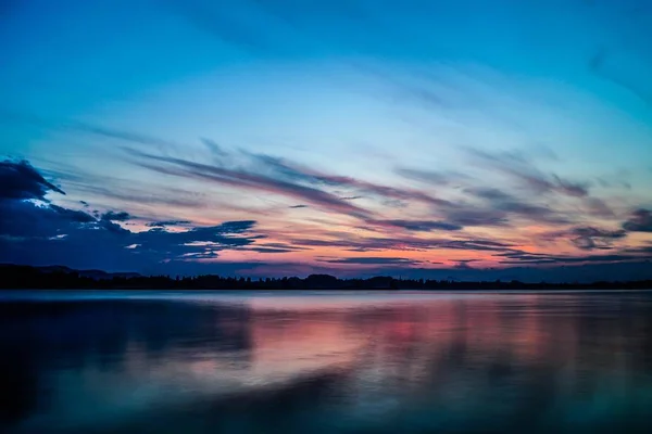 Sunset with beautiful clouds mood lake constance blue hour