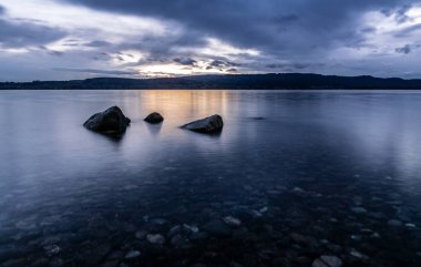 Mavi saatte güzel bulut ruh hali ve taş su ile Konstanz Gölü