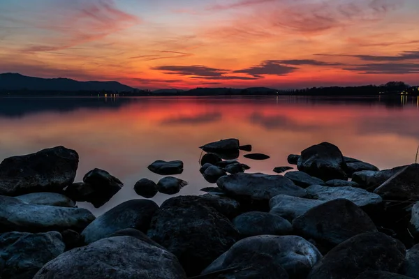 湖锥形湖海岸与石头在水红色日落 — 图库照片