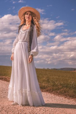 güzel elbise ve mavi gökyüzü ile baharda bir kir yolda kadın