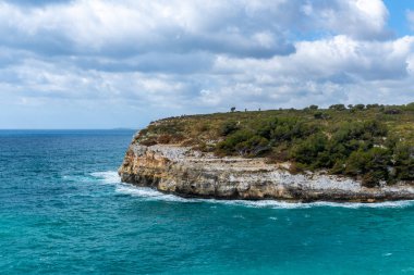 Deniz manzaralı doğu kıyısı kayalıkları ve mavi gökyüzü Cala Romantica Manacor Mallorca