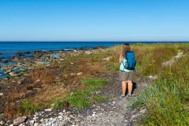 Female hiker with backpack at Baltic Sea coast near Cape Arkona Ruegen Germany