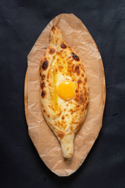 siyah bir arka plan üzerinde ahşap bir tahta üzerinde khachapuri