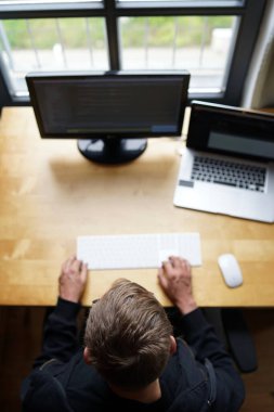 Laptop ve harici monitörle evden klavye ve fare ile çalışan programcının en iyi görüntüsü.