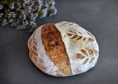 Arka planda otlar ve siyah taş üzerinde taze pişmiş, ekşi ekşi ekmek.