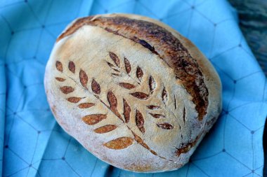 Bulaşık bezinde tohum olan ev yapımı buğday ekmeği; arka planda tahta tahtalar.