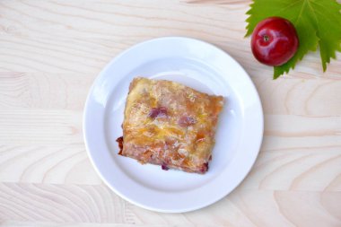 Arka planda elma ve üzümlü ev yapımı elmalı turta; tereyağı, elma, şeker ve tarçınla doldurulmuş taze, ev yapımı hamur; geleneksel Slovenya ve Avusturya tatlısı