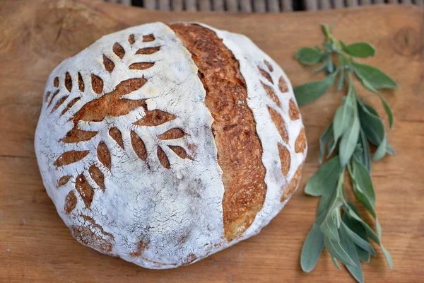 木の板にりんごを乗せた自家製の小麦パンと背景にセージ パンの得点とソース生地のパン — ストック写真