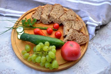 Ev yapımı ekmek deseni tohumlu kara buğday ekmeği, tahta üzerinde meyve ve sebzeli dilimlenmiş ekmek.