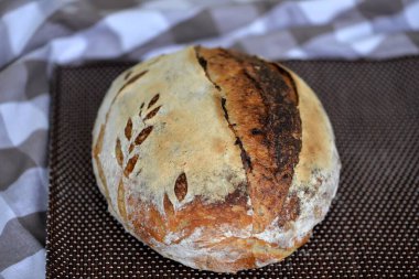 Kahverengi tahtada ev yapımı buğday ekmeği; kabuklu ekşi ekmek