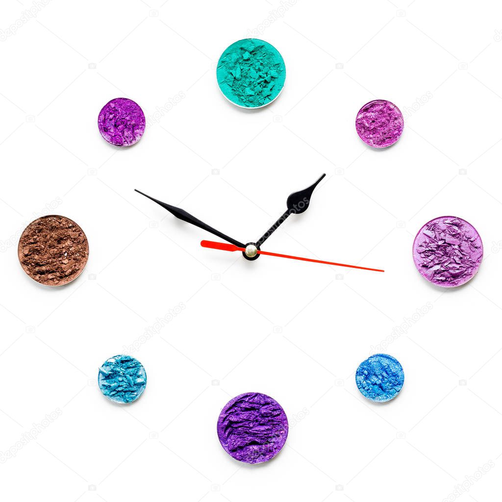 Creative concept photo of cosmetics swatches in the shape of clock on white background.