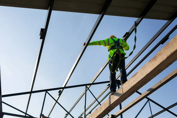 아시아 노동자들은 현장에 지붕을 설치하기 높이의 장비를 착용하고 몸체를 갈고리를 — 스톡 사진