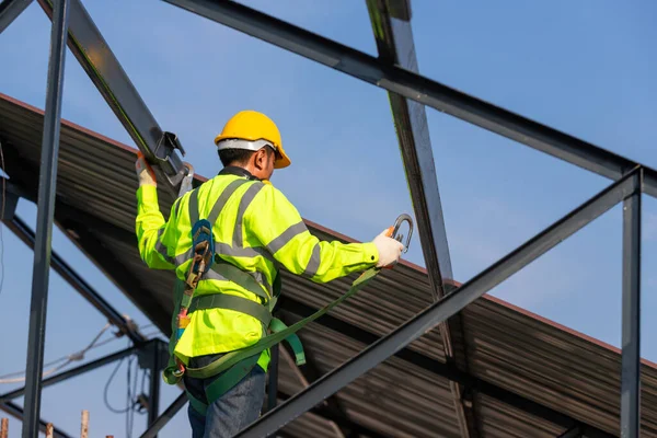 Asian roof construction worker wear safety height equipment to install the roof frame, Fall arrestor device for worker with hooks for safety body harness in the construction site.