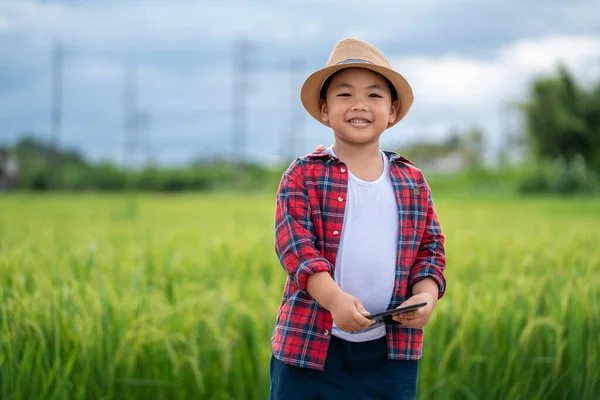 Azji Mały Chłopiec Tabletem Patrząc Aparat Zainteresowany Nauką Otoczenia Zielonych — Zdjęcie stockowe