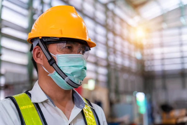 Asian male engineer wearing protective mask to Protect Against Covid-19 in the factory,Coronavirus has turned into a global emergency,Coronavirus Disease 2019 (COVID-19).
