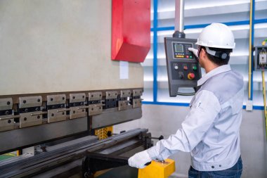 Güvenlik kıyafeti giyen Asyalı teknisyen Hidrolik Basın Kırma Makinesi ve endüstriyel fabrikada Hazır Metal Kaydırma, Önce Güvenlik