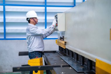 Güvenlik kıyafeti giyen Asyalı işçiler ve endüstriyel fabrikada Hidrolik Basın Kırma Makinesi ve Hazır Metal Makası ilk konsept güvenlik.