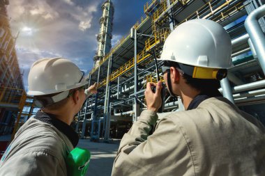 Sanayi mühendisi ya da işçi telsiz iletişimi petrol ve gaz rafinerisi fabrika sanayi bölgesi güneş doğumu ve bulutlu gökyüzü, petrol ve gaz endüstrisi kavramı ile kontrol odasına.