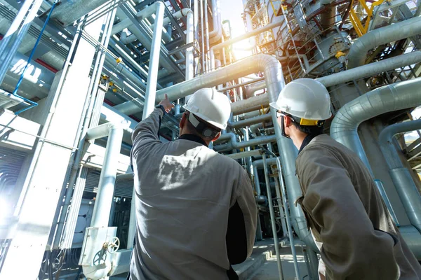 Petrol ve gaz rafinerisindeki boru hattını kontrol eden sanayi mühendisi veya işçi güneş doğumu ve bulutlu gökyüzü, petrol ve gaz endüstrisi kavramı ile sanayi alanı.