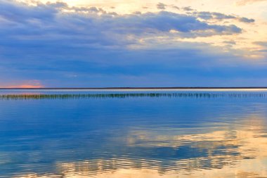 Güzel manzara ile göl. Gökyüzü ve bulutlar içinde gölün yüzeyi pürüzsüz yansıtır.