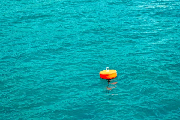 Orange buoy on the turquoise sea.A buoy is a floating device that can have many purposes.