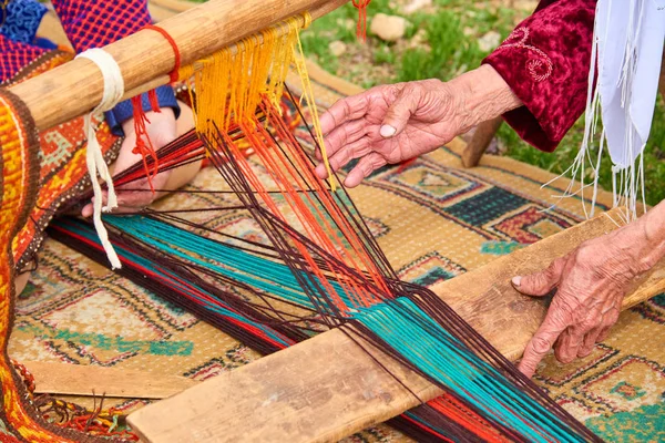 Carpet weaving.Woman hands weaving carpet on the loom.