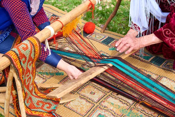 Carpet weaving.Woman hands weaving carpet on the loom.