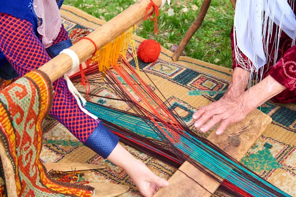 Carpet weaving.Woman hands weaving carpet on the loom.