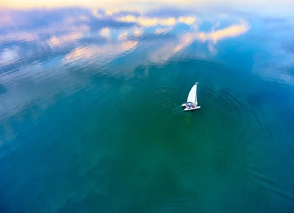 夕暮れ時 ターコイズ ブルーの湖でセーリング カタマラン ボート 上からの眺め 美しい夕日 夕暮れ時のピンクの雲の反射 水の上のピンクの雲の反射 — ストック写真