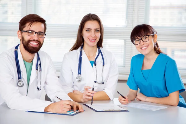 Gruppe Von Ärzten Der Klinik Arbeitsplatz Blickt Die Kamera Und — Stockfoto