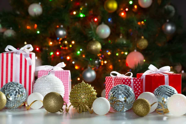 Karácsonyi Ajándékok Labdák Hátterében Egy Ünnepi Karácsonyfa — Stock Fotó
