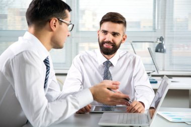 Ofiste dizüstü bilgisayarla çalışan iş adamları