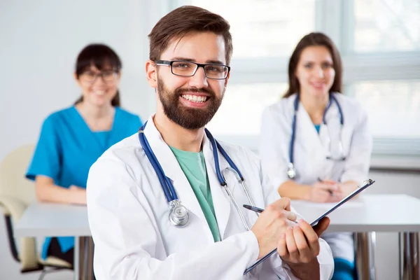 Retrato Joven Médico Una Clínica Con Colegas Fondo —  Fotos de Stock