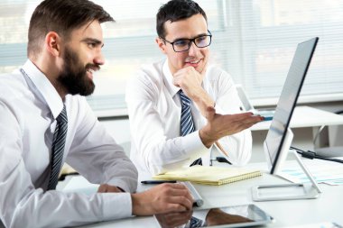 Genç işadamları ofiste yeni projeyi tartışıyor