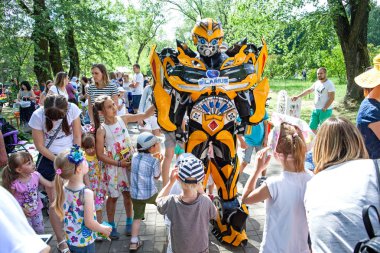 Minsk, Beyaz Rusya, 3 Haziran 2018: Animator ile robot trafo bir şehir parkta çocuklar arasında bir takım elbise.