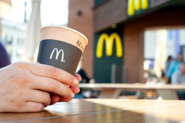 Minsk, Beyaz Rusya, 02 Temmuz 2019: Mcdonald's Restaurant terasında Elinde Mcdonald's logosu olan kağıt kahve