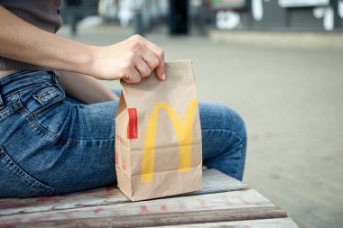 Minsk, Beyaz Rusya, 02 Temmuz 2019: Kağıt torba Mcdonald's bir kadının yanında bir bankta.