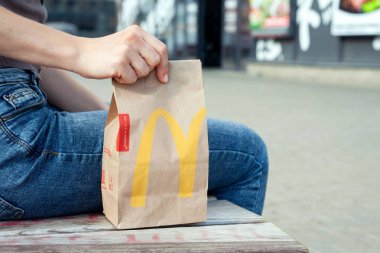 Minsk, Beyaz Rusya, 02 Temmuz 2019: Kadın elinde Mcdonald's restorandan öğle yemeği ile paket kağıt torba tutar