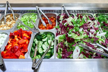 Malzemelerin çeşitli taze ürün yelpazesine sahip taze salata bar. Süpermarket veya restoranda müşteri seçimi için seçeneklerin alanını görüntüleme