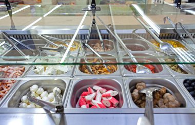 Malzemelerin çeşitli taze ürün yelpazesine sahip taze salata bar. Süpermarket veya restoranda müşteri seçimi için seçeneklerin alanını görüntüleme