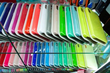 Vitrindeki akıllı telefonlar için çok renkli davalar. Akıllı telefonunuz için dosya seçiliyor.