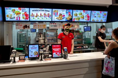 MINSK, BELARUS - 11 Haziran 2020: Tıbbi maskeli işçiler Coronavirus salgını sırasında KFC restoranında müşterilere hizmet veriyor. Salgın sırasında yaşam biçimi.