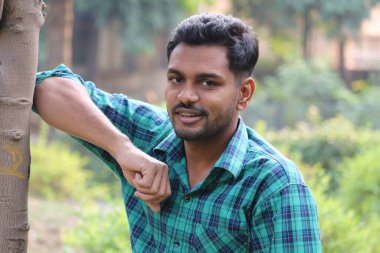 Yakışıklı çocuk gülümsüyor Bahçede duruyor 