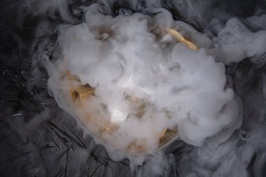 Sis siyah arka plan üzerinde kuru buz etkisi ile dondurulmuş Kuru buzun içinde kalbimle plastik wrap