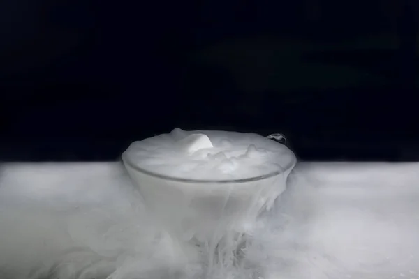 The frozen of dry ice with white smoky in glass on darkness background