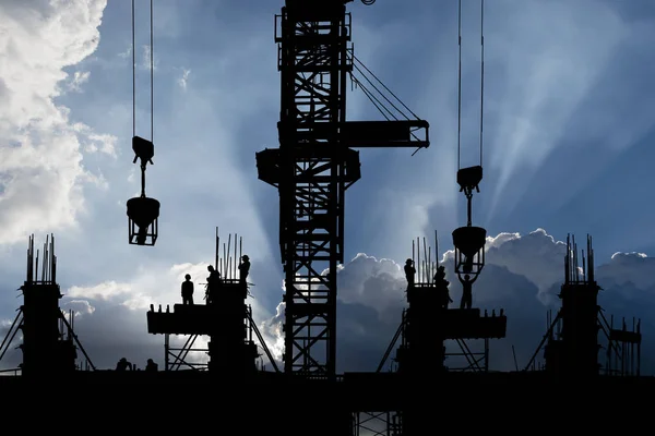 Silhouette of construction site & workers with ray of light background