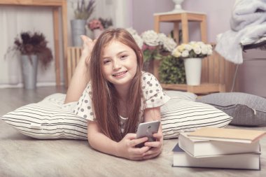 Sevimli küçük kız almak öğrenme telefon oturma odasında sosyal medya, mobil aile ile Facetime üzerinde kızı