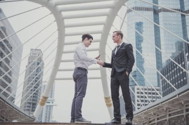 Genç İşadamları bir yatırım hakkında akıllı telefon planı kontrol ve patronu ile el sallayarak 