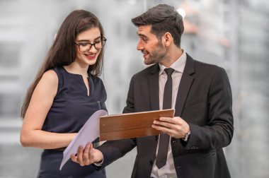 Sekreter ofiste müdürle konuşuyor.